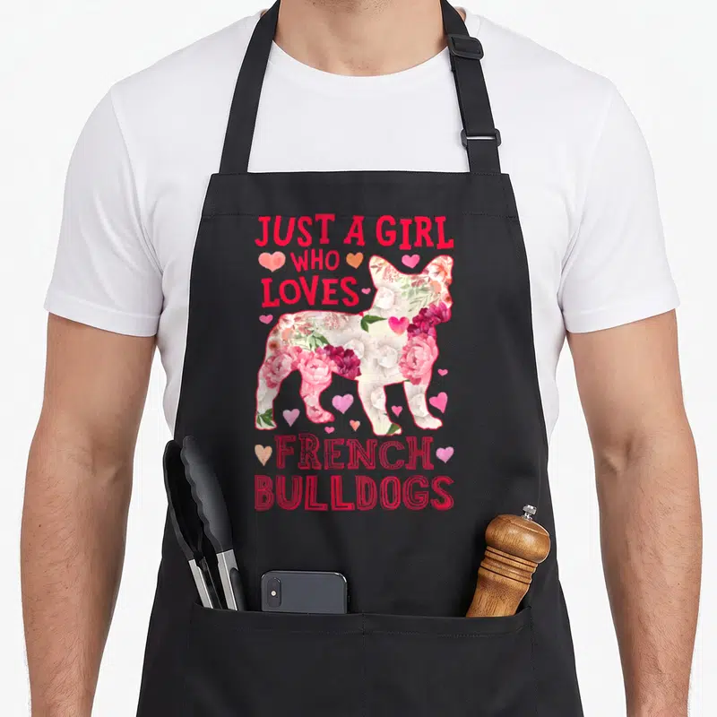 Dog french apron - Floral French Bulldog silhouette with red text Just A Girl Who Loves French Bulldogs and pink hearts — shown on a black cotton canvas apron against a white background