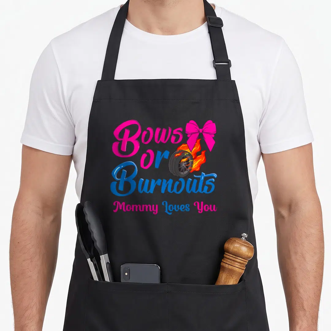 Burnout gender bow apron - Flaming car wheel with pink bow and Bows or Burnouts Mommy Loves You text in pink and blue — shown on a black cotton canvas apron against a white background