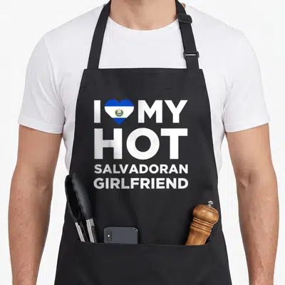 Hot salvadoran apron - White stacked text reading I MY HOT SALVADORAN GIRLFRIEND with a blue and white flag heart — shown on a black cotton canvas apron against a white background