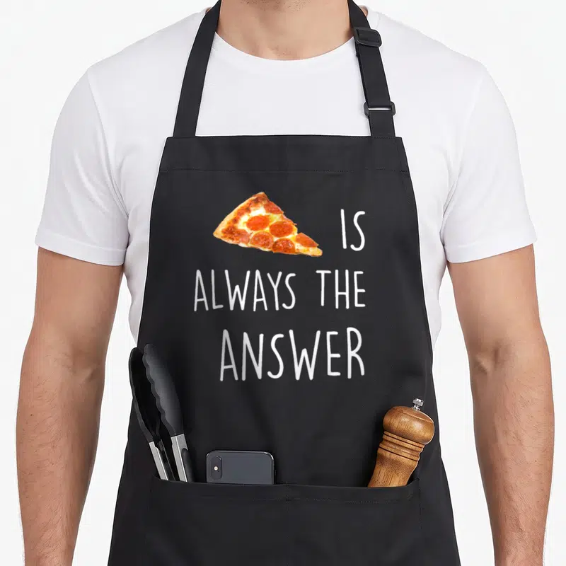 Alway pizza apron - Pepperoni slice replacing text IS ALWAYS THE ANSWER in white and red — shown on a black cotton canvas apron against a white background