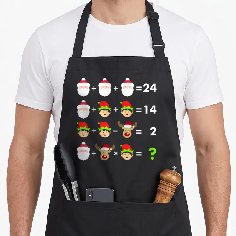Teacher christmas apron - Four rows of math equations with Santa, elf, and reindeer heads ending in equals signs — shown on a black cotton canvas apron against a white background