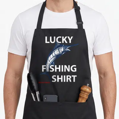 Lucky fisherman fishing apron - Navy marlin graphic with LUCKY FISHING SHIRT text and small red warning label — shown on a black cotton canvas apron against a white background