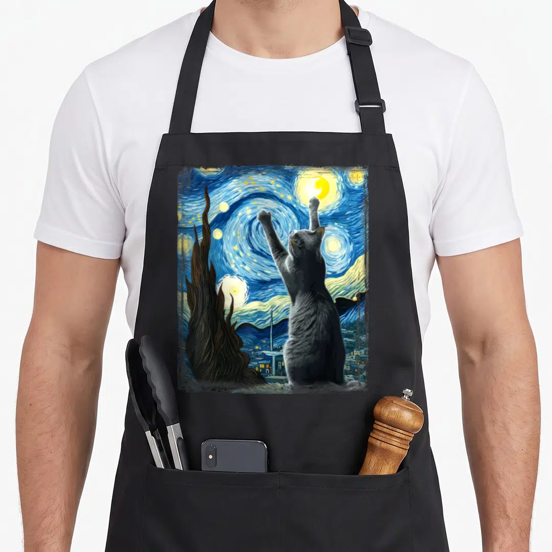 Van russian aprons - Grey cat reaching up at yellow moon and stars in blue swirls with brown cypress tree — shown on a black cotton canvas apron against a white background