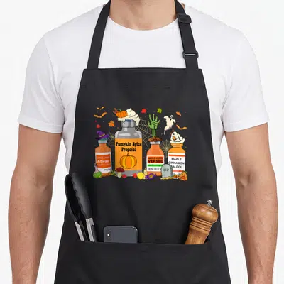 Propofol spice apron - Four cartoon medicine bottles labeled Pumpkin Spice Propofol and Maple Cinnamon Haldol — shown on a black cotton canvas apron against a white background