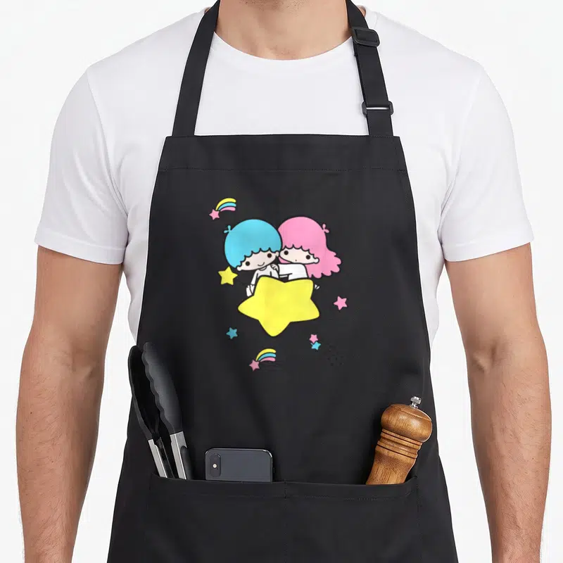 Twin shooting apron - Two cartoon children hugging behind a large yellow star with smaller blue, pink, and white — shown on a black cotton canvas apron against a white background