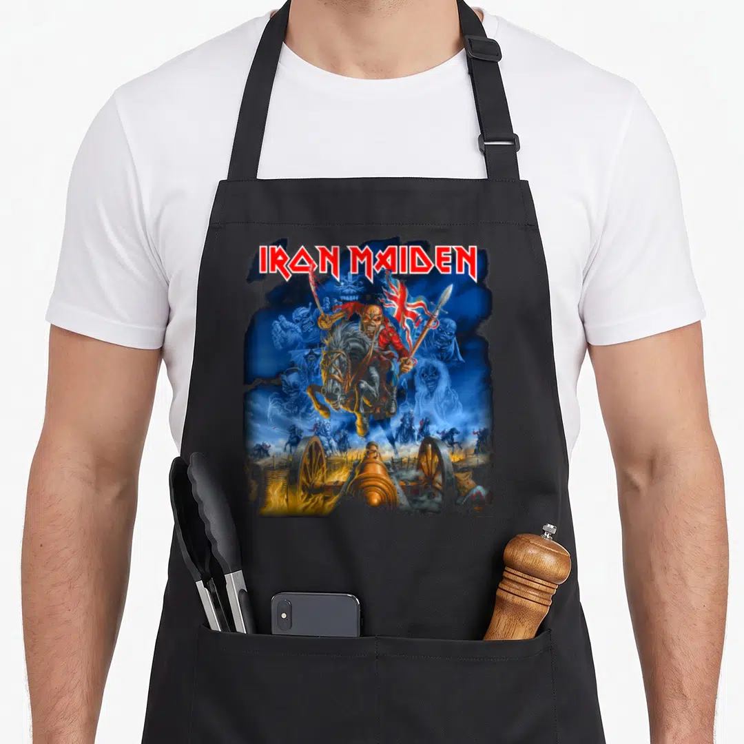 Funny trooper camping apron - Iron Maiden text above Eddie on horse with cannon and skeletons in blue red gold white — shown on a black cotton canvas apron against a white background