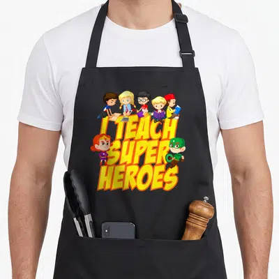 Heroe teaching teacher apron - Yellow text I Teach Super Heroes with five students sitting on letters and two cartoon — shown on a black cotton canvas apron against a white background