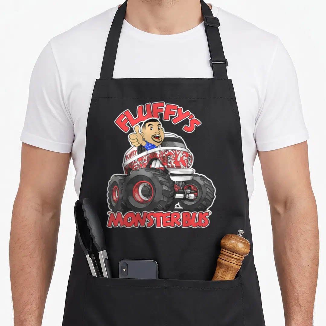 Gabriel truck aprons - Cartoon man thumbs up in red white monster bus with Fluffy's Monster Bus text — shown on a black cotton canvas apron against a white background