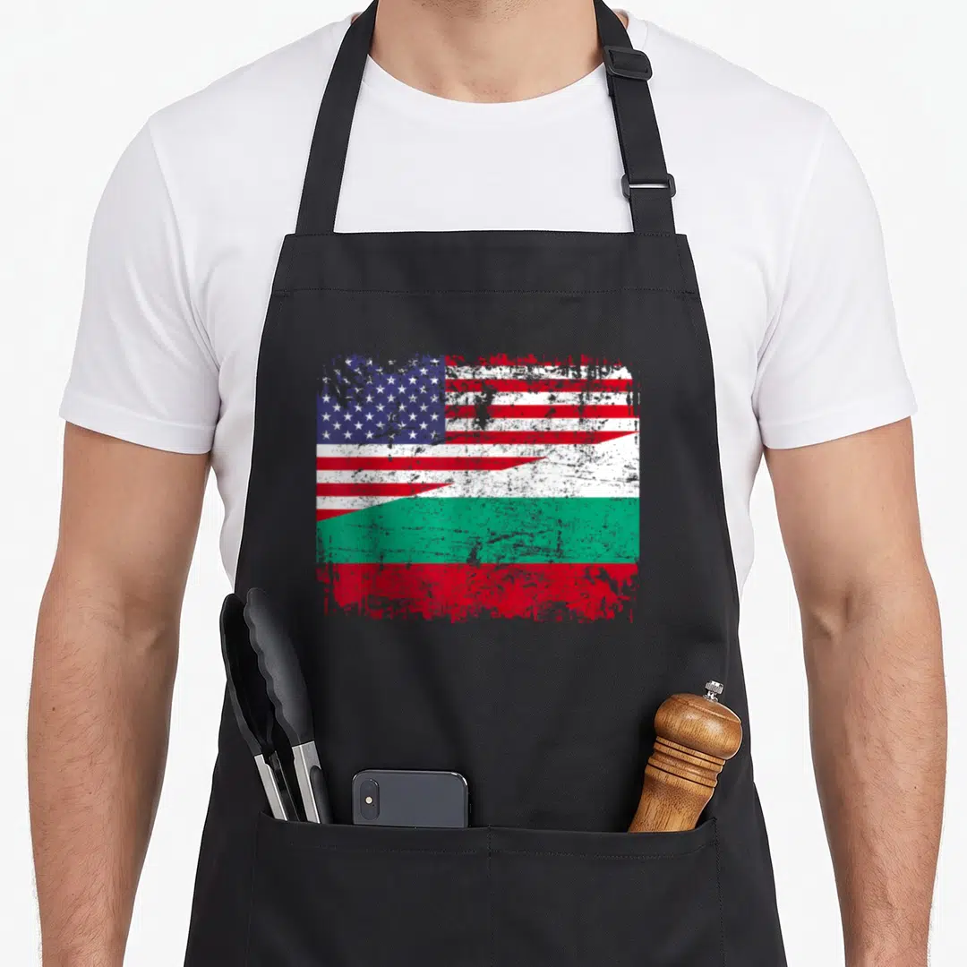 Bulgarian root american flag apron - Distressed merged US and Bulgaria flag print in red white blue green — shown on a black cotton canvas apron against a white background