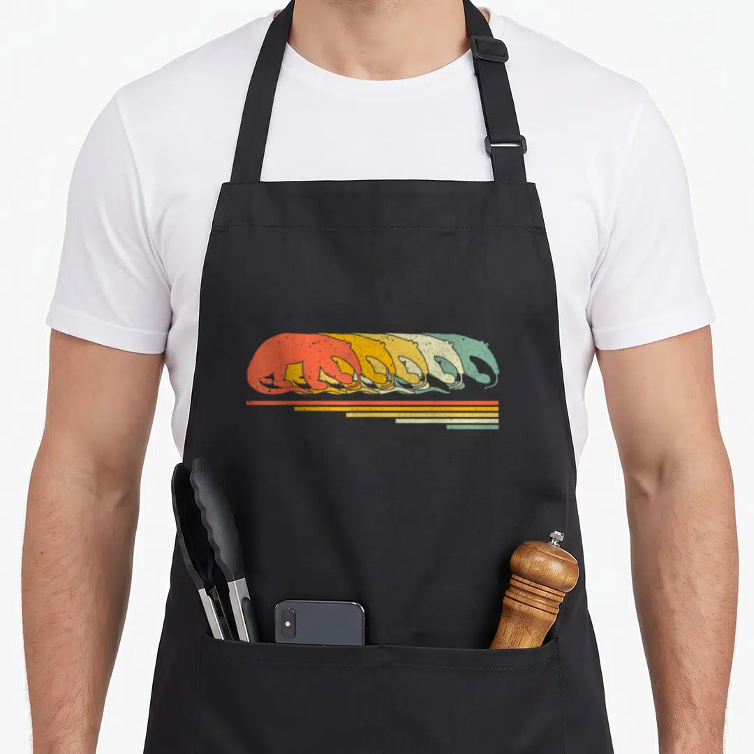 Anteater 70s apron - Five layered otters in red, yellow, cream, green, and teal with matching horizontal stripes — shown on a black cotton canvas apron against a white background