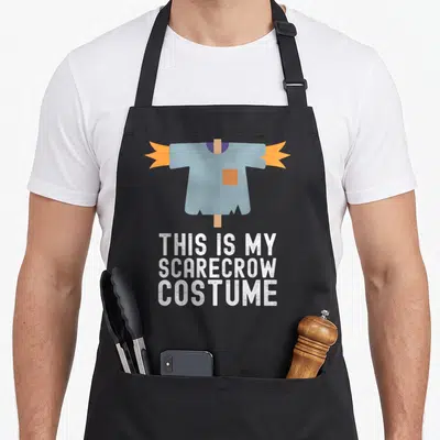 Easy pretend halloween apron - Cartoon blue shirt on brown post with white text THIS IS MY SCARECROW COSTUME — shown on a black cotton canvas apron against a white background