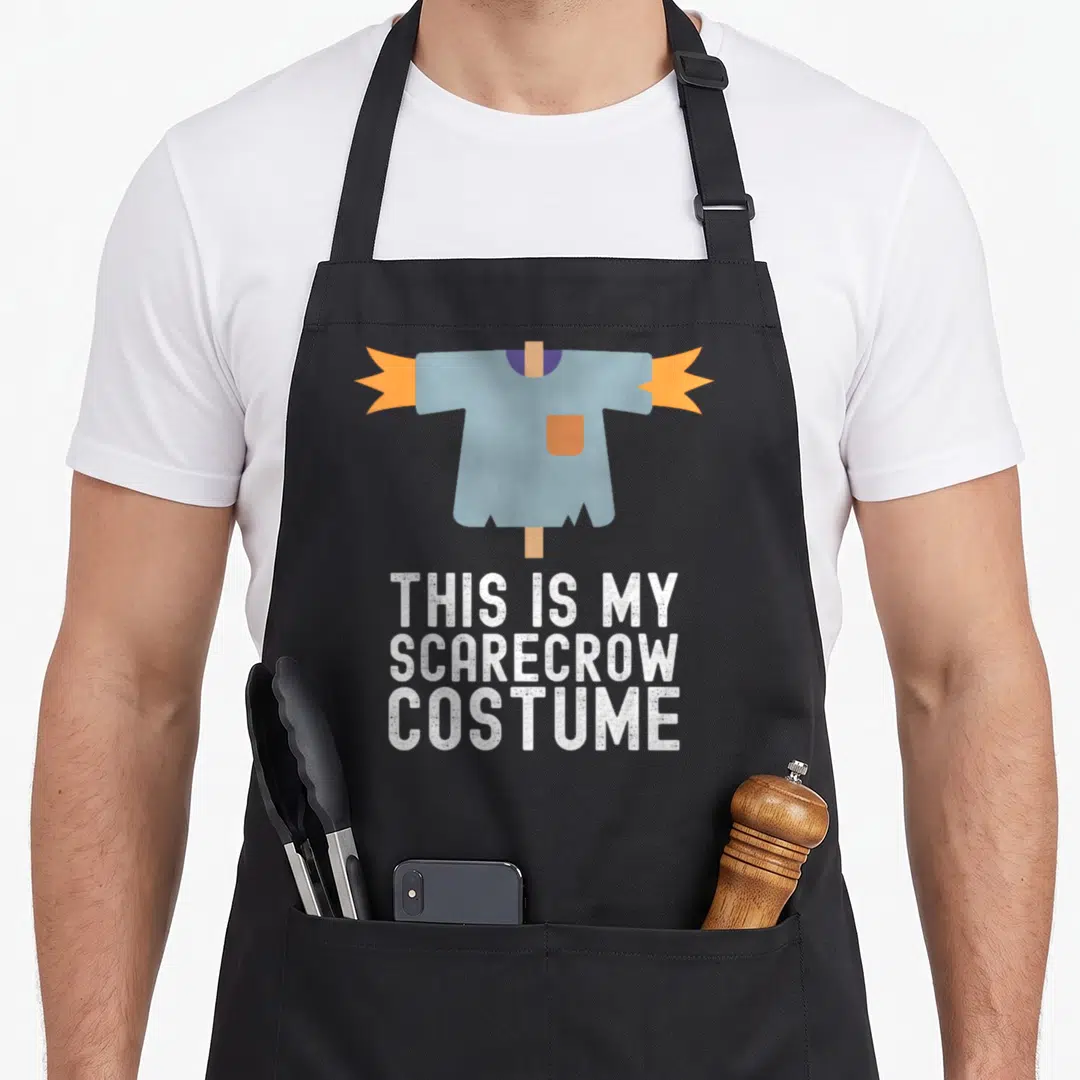 Easy pretend halloween apron - Cartoon blue shirt on brown post with white text THIS IS MY SCARECROW COSTUME — shown on a black cotton canvas apron against a white background