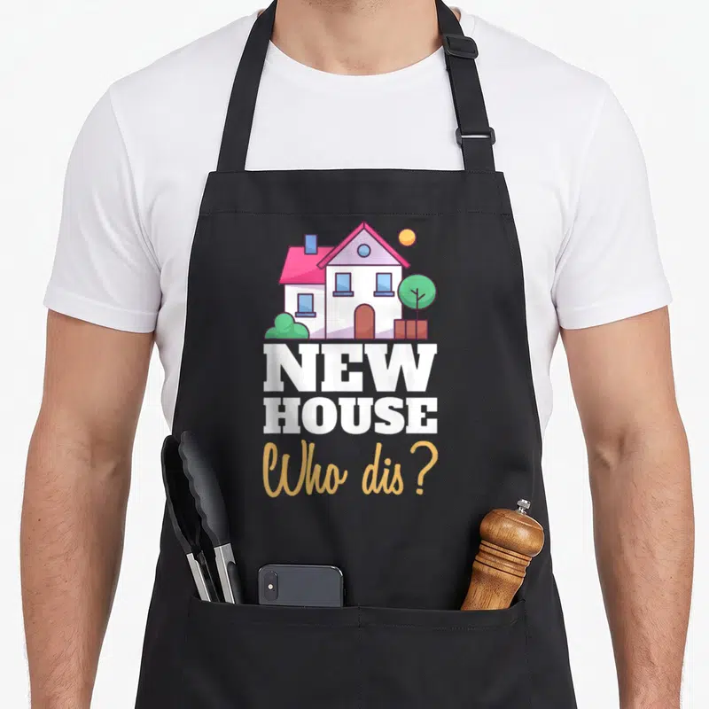 Dis novelty apron - Cartoon house with sun and fence above white and gold text reading NEW HOUSE Who dis — shown on a black cotton canvas apron against a white background