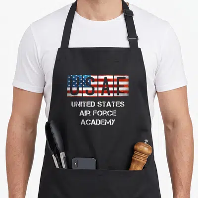 Base us aprons - USAF text filled with US flag pattern above three lines of distressed text reading United States Air — shown on a black cotton canvas apron against a white background