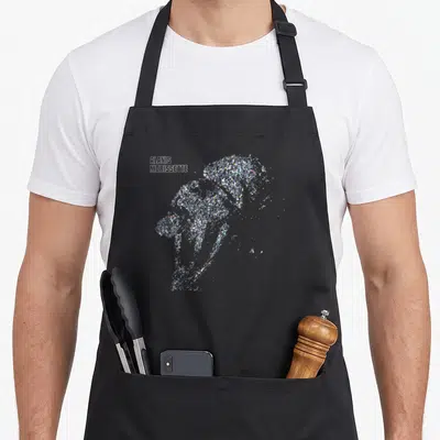 Alanis road apron - Silver glitter woman silhouette with white Alanis Morissette text on grey background — shown on a black cotton canvas apron against a white background