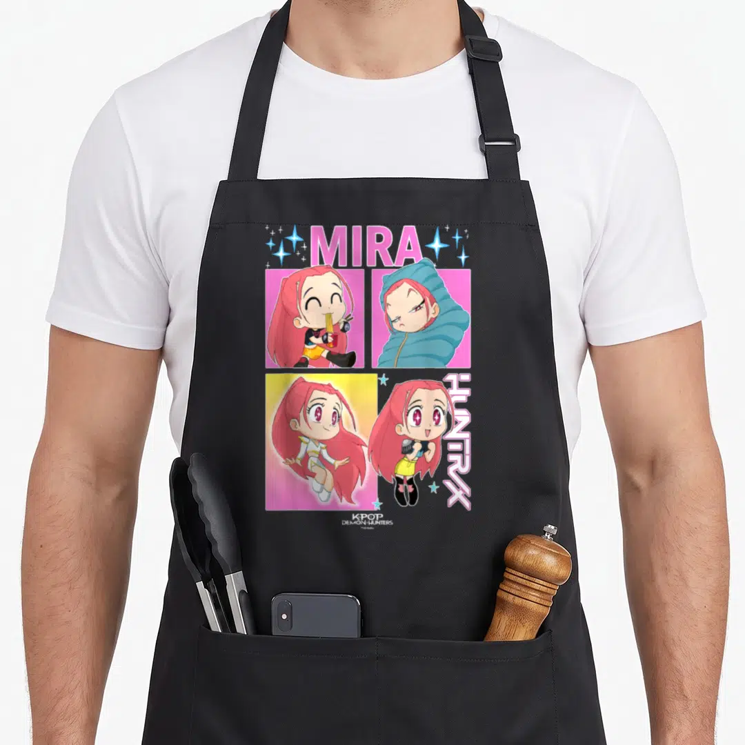 Mira novelty apron - MIRA and HUNTRX text with four cartoon girl panels in pink, blue, yellow, and white — shown on a black cotton canvas apron against a white background