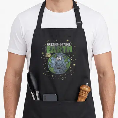 Schoolhouse friends apron - Cartoon Earth character with FRIEND OF THE EARTH text and scattered yellow stars — shown on a black cotton canvas apron against a white background