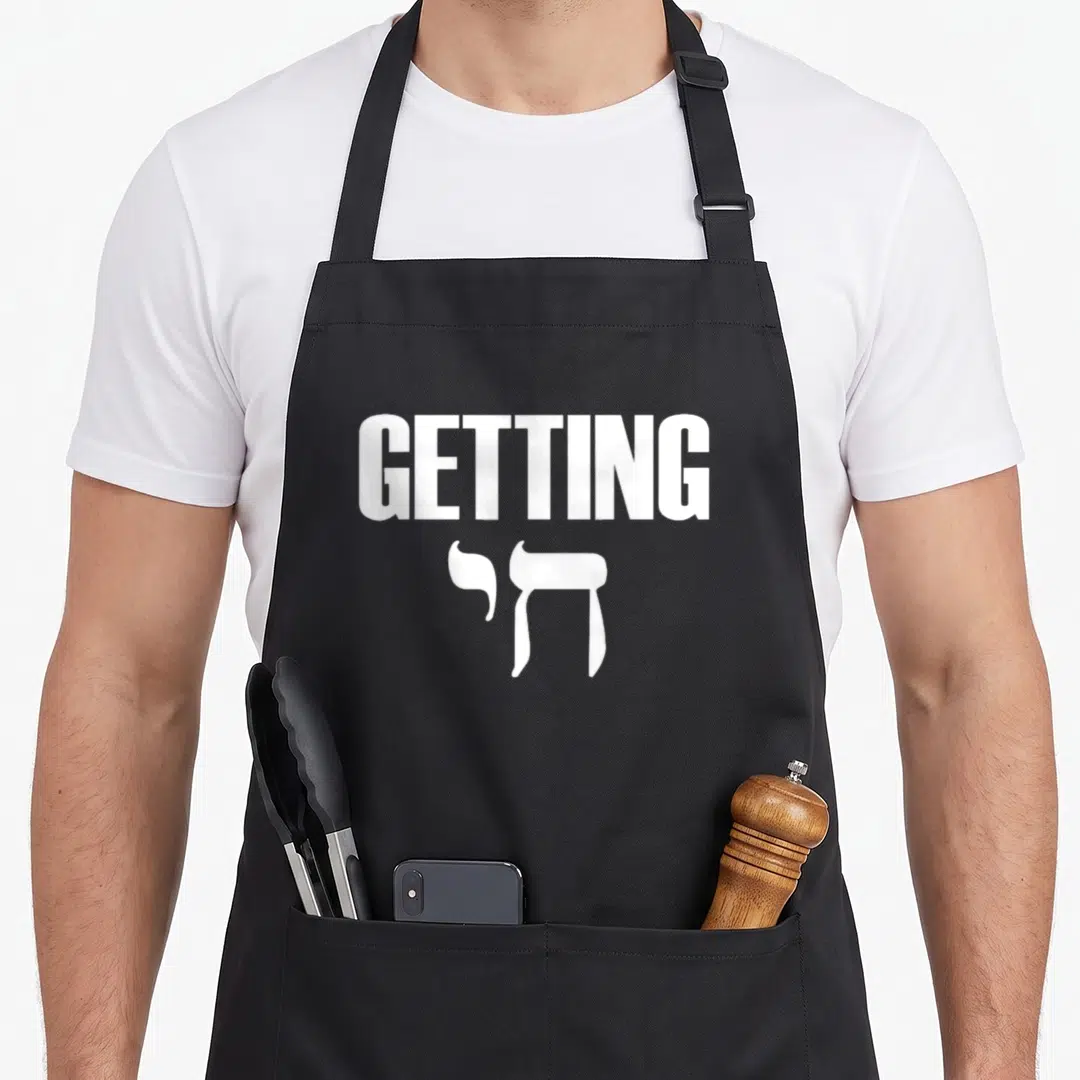 Getting chai jewish aprons - White text reading GETTING above two Hebrew letters on grey background — shown on a black cotton canvas apron against a white background