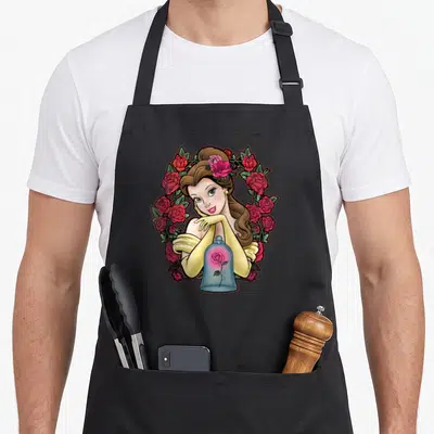 Belle rose apron - Cartoon woman in wreath of pink and red roses with blue glass dome holding single rose — shown on a black cotton canvas apron against a white background