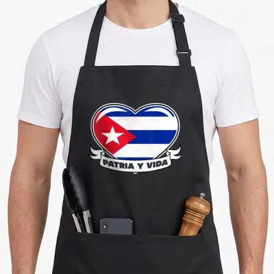 Cuban proud american flag apron - Heart shaped Cuban flag with PATRIA Y VIDA ribbon banner — shown on a black cotton canvas apron against a white background