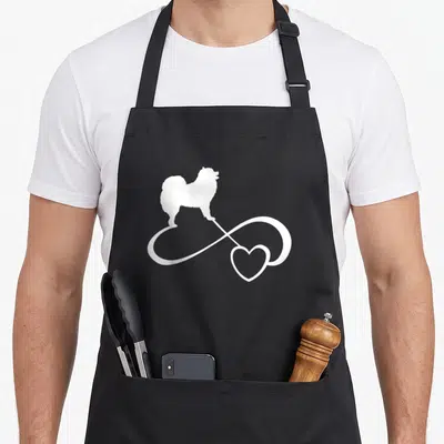Samoyed dog breed aprons - White dog silhouette on infinity heart symbol — shown on a black cotton canvas apron against a white background