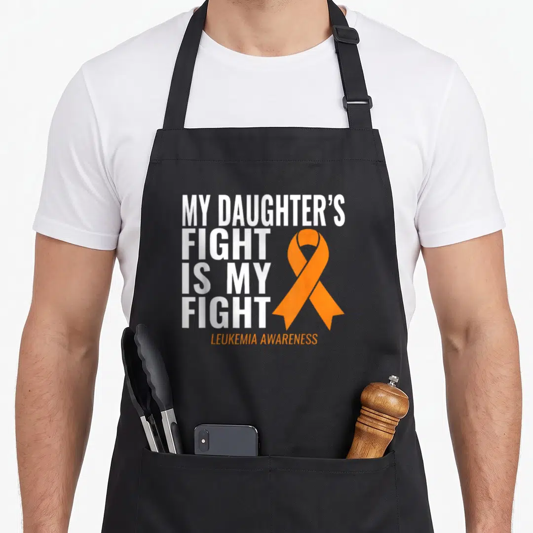 Daughter leukemia awareness apron - White stacked text MY DAUGHTER'S FIGHT IS MY FIGHT beside orange ribbon on black — shown on a black cotton canvas apron against a white background