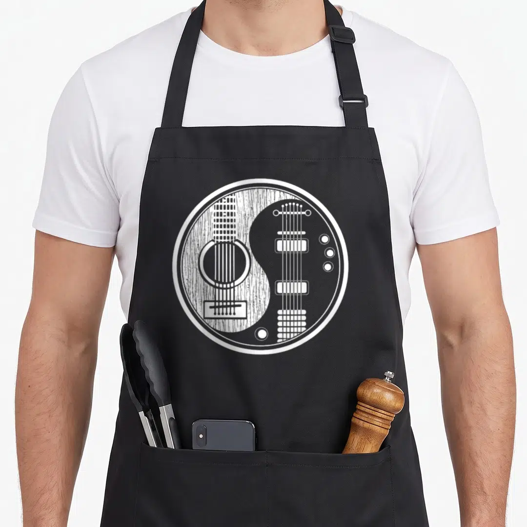 Ying acoustics apron - White line art yin yang formed by acoustic and electric guitar silhouettes on black fabric — shown on a black cotton canvas apron against a white background