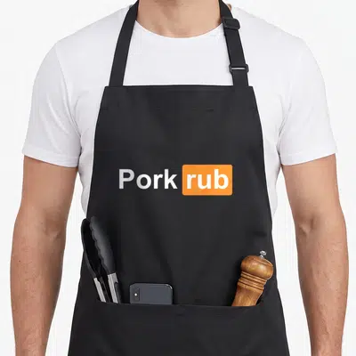 Pork barbecue apron - White Pork rub text next to an orange rounded rectangle containing the word rub — shown on a black cotton canvas apron against a white background