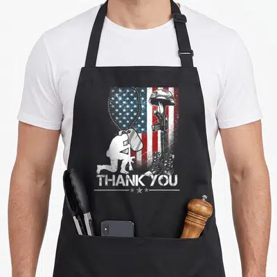 Memorial dog apron - Kneeling soldier silhouette, distressed flag, THANK YOU text, three stars, military gear memorial — shown on a black cotton canvas apron against a white background