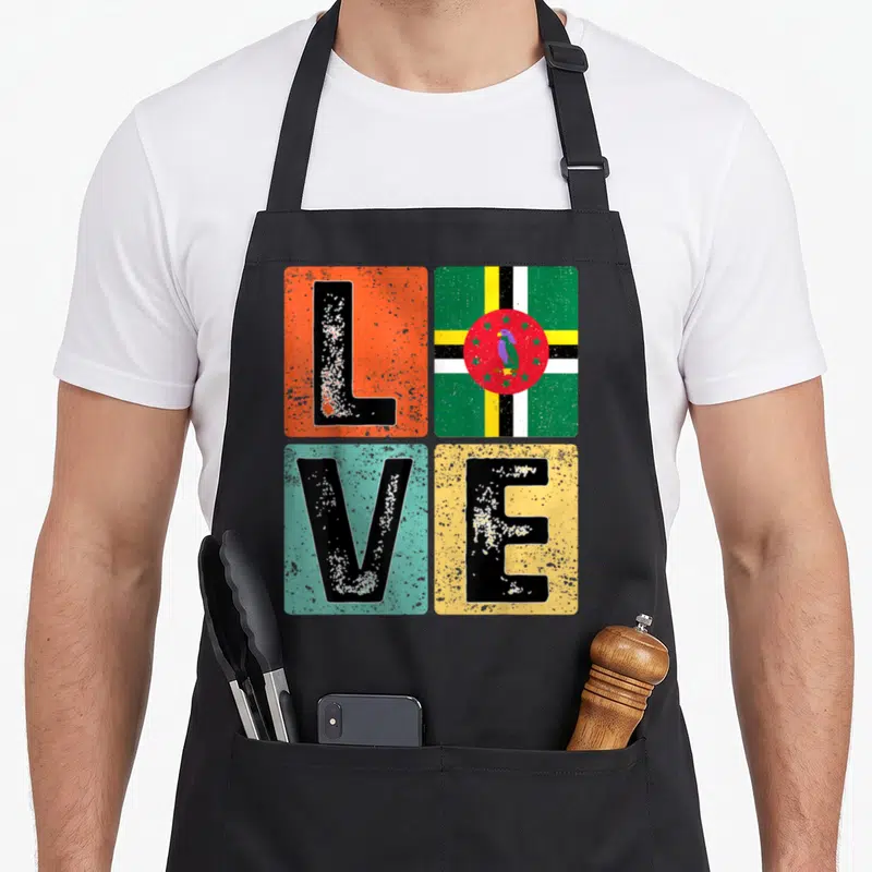 Dominica pride apron - Distressed LOVE text in colored squares with Dominican flag and parrot inside the O — shown on a black cotton canvas apron against a white background