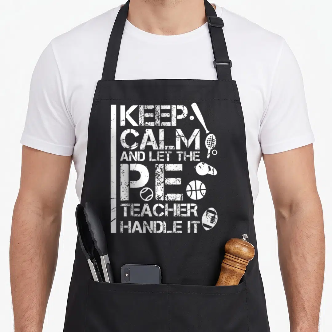 Handle teacher apron - Distressed white text and sports equipment including bat, racket, and whistle — shown on a black cotton canvas apron against a white background