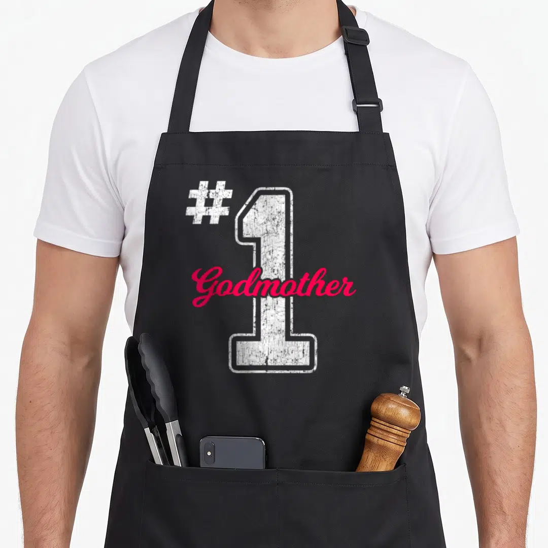 Number unity day apron - White distressed number 1 with pink Godmother script and hashtag symbol — shown on a black cotton canvas apron against a white background