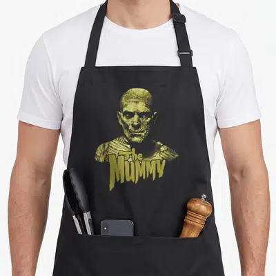 Dark mummy and me aprons - Yellow distressed mummy bust with The MUMMY text overlapping the chest area — shown on a black cotton canvas apron against a white background