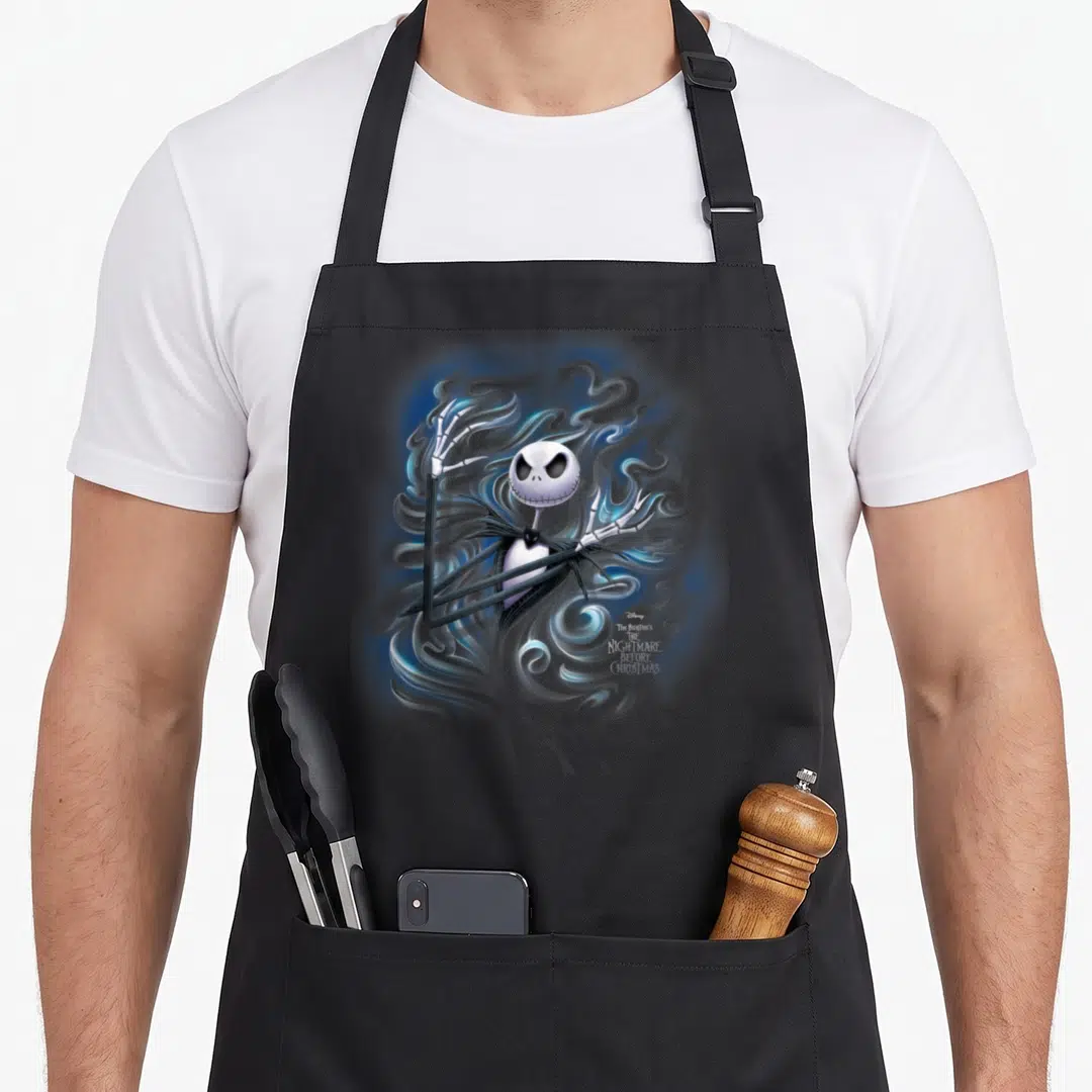 Fog jack lover apron - Jack Skellington surrounded by swirling blue and grey smoke with movie title text — shown on a black cotton canvas apron against a white background