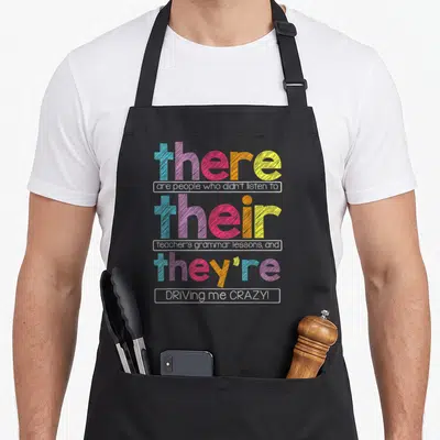 Their teacher apron - Stacked colorful text reading there are people who didn't listen to their teacher's grammar — shown on a black cotton canvas apron against a white background