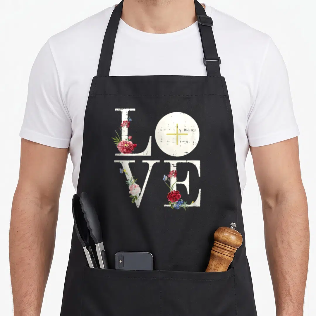 Eucharist communion aprons - LOVE text with white circle yellow cross red blue flowers and butterflies — shown on a black cotton canvas apron against a white background