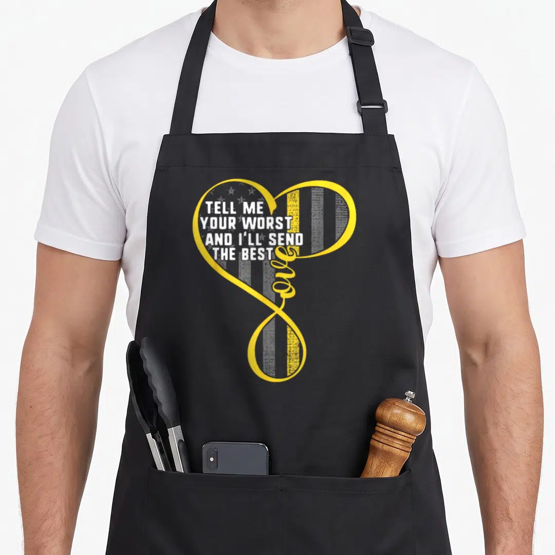 Worst dispatcher apron - Yellow heart outline with white text tell me your worst and ill send the best and vertical — shown on a black cotton canvas apron against a white background