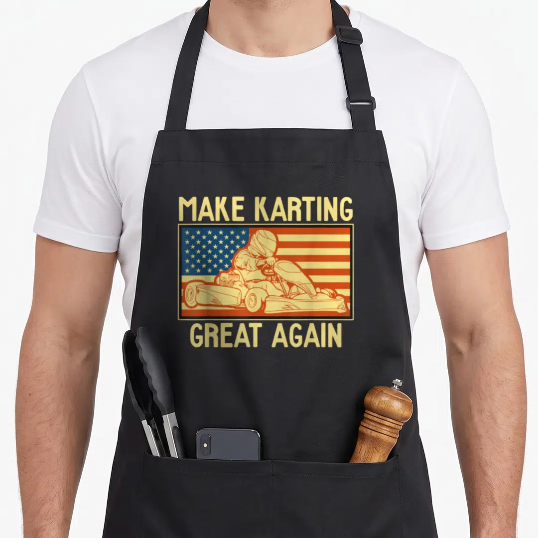 Funny kart karting apron - Retro go-kart driver illustration with flag background and text — shown on a black cotton canvas apron against a white background