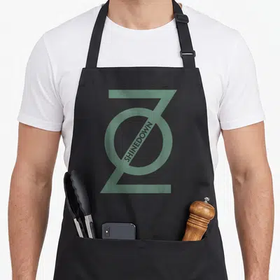 Shinedown zero apron - Green stylized Z logo with diagonal SHINEDOWN text on black background — shown on a black cotton canvas apron against a white background