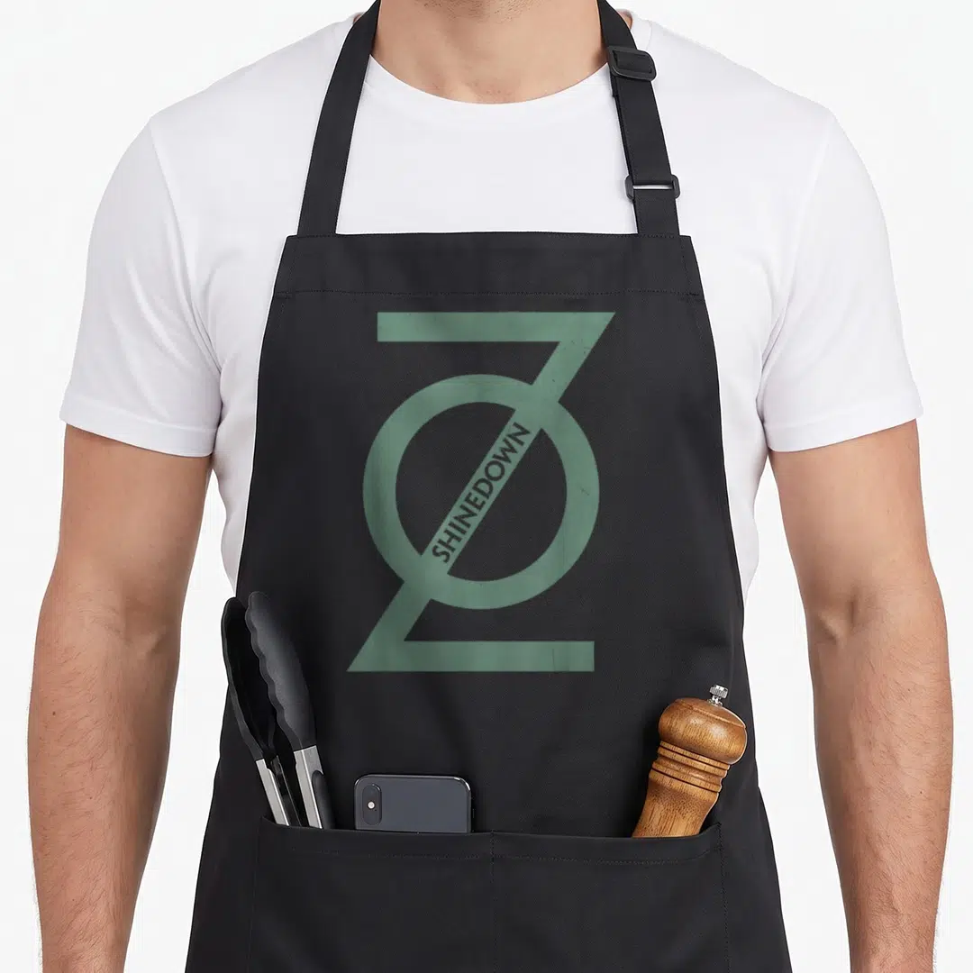 Shinedown zero apron - Green stylized Z logo with diagonal SHINEDOWN text on black background — shown on a black cotton canvas apron against a white background