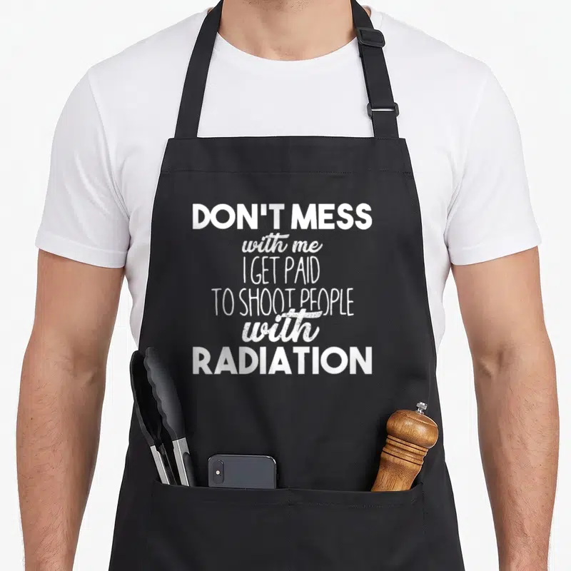 Mess x ray radiation apron - White stacked text reading Don't Mess with me I Get Paid To Shoot People With Radiation — shown on a black cotton canvas apron against a white background