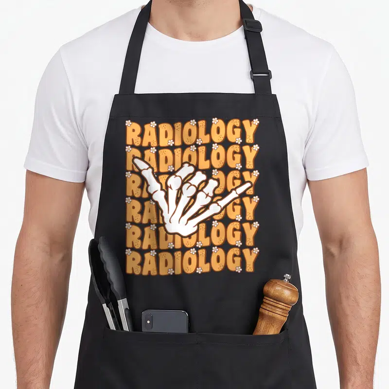 Shaka x ray apron - White skeleton hand shaka sign over six orange RADIOLOGY lines with white flowers — shown on a black cotton canvas apron against a white background