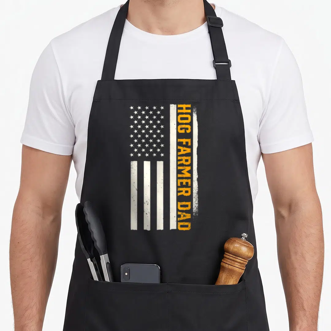 Patriotic farming apron - Distressed white and orange flag with vertical HOG FARMER DAD text on right side — shown on a black cotton canvas apron against a white background