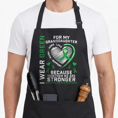 Grandpa grandma granddaughter aprons - I Wear Green For My Granddaughter Cerebral Palsy Awareness text with white heart — shown on a black cotton canvas apron against a white background