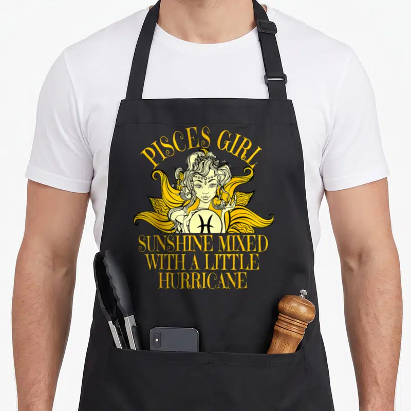 Sunshine pisces girl apron - Cartoon girl holding Pisces symbol with yellow and black text reading Sunshine Mixed — shown on a black cotton canvas apron against a white background