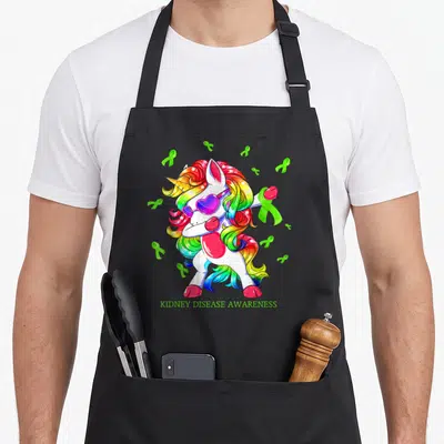 Disease unicorn apron - Rainbow mane dabbing unicorn with green kidney disease awareness ribbons and heart sunglasses — shown on a black cotton canvas apron against a white background