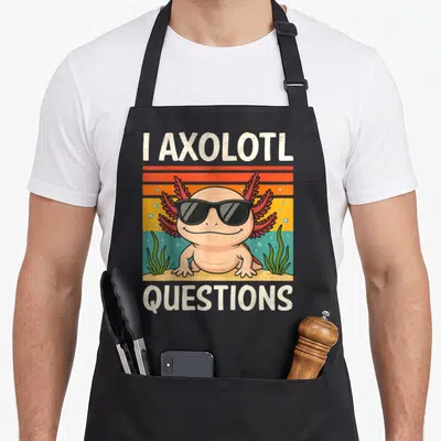 Youth axolotl question apron - Cartoon axolotl in sunglasses with I AXOLOTL QUESTIONS text on retro striped background — shown on a black cotton canvas apron against a white background