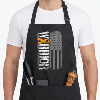 Sideway ribbon apron - Vertical MY WARRIOR text with orange ribbon over distressed grey flag pattern — shown on a black cotton canvas apron against a white background