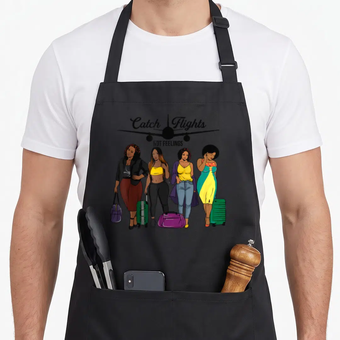 Catch travel aprons - Four women with luggage under Catch Flights text and airplane silhouette in cartoon style — shown on a black cotton canvas apron against a white background