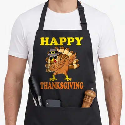Vintage turkey thanksgiving apron - Cartoon turkey in sunglasses and hat between HAPPY THANKSGIVING text — shown on a black cotton canvas apron against a white background